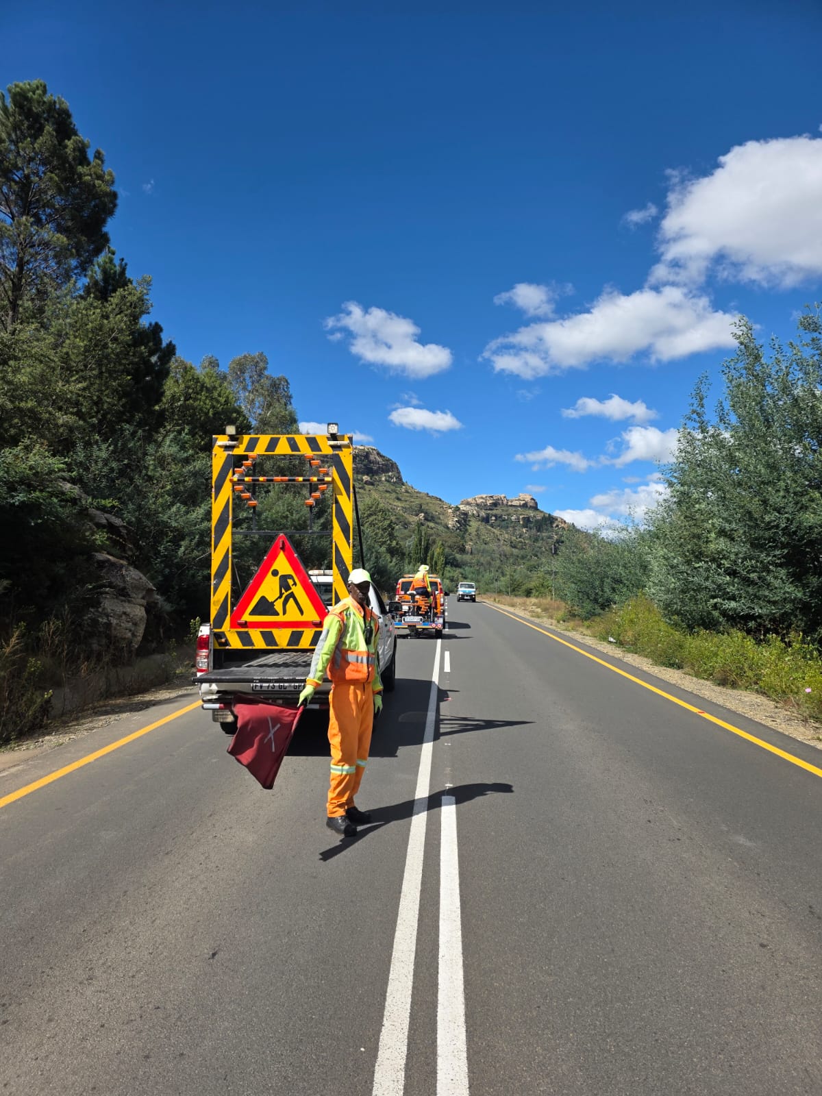 Traffic officer directing vehicles on a rural mountain road