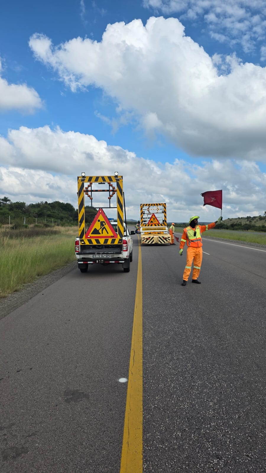 Traffic safety officer flagging traffic on a highway lane closure