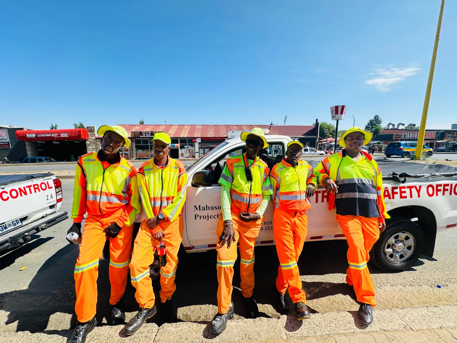 Traffic safety team in high-visibility gear beside a company bakkie