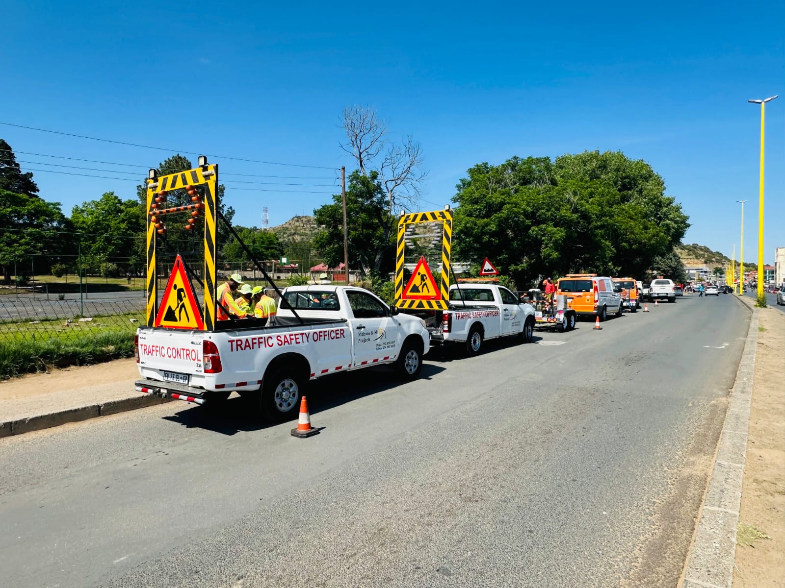 Convoy of traffic safety vehicles positioned along a roadside